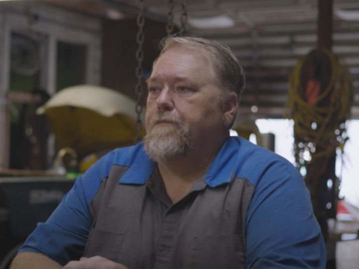 Man sitting in car repair shop