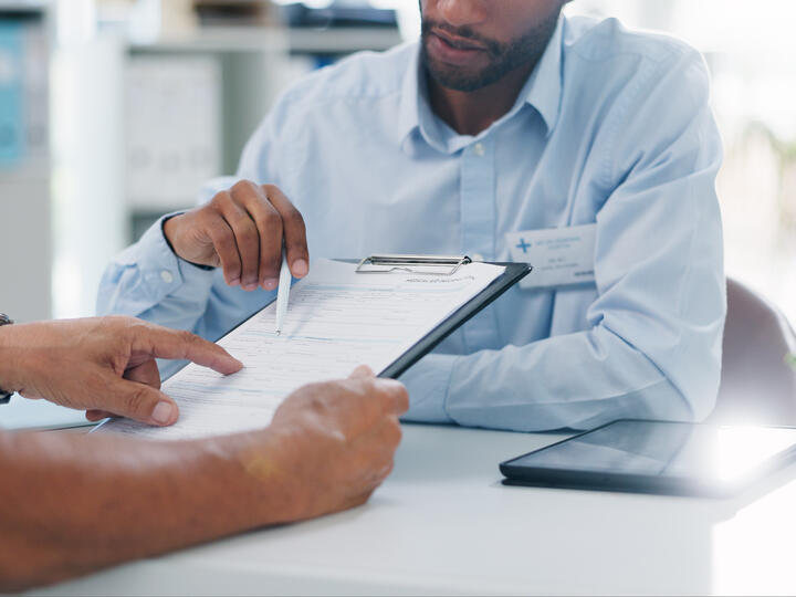 Photos of man explaining medical forms to a patient